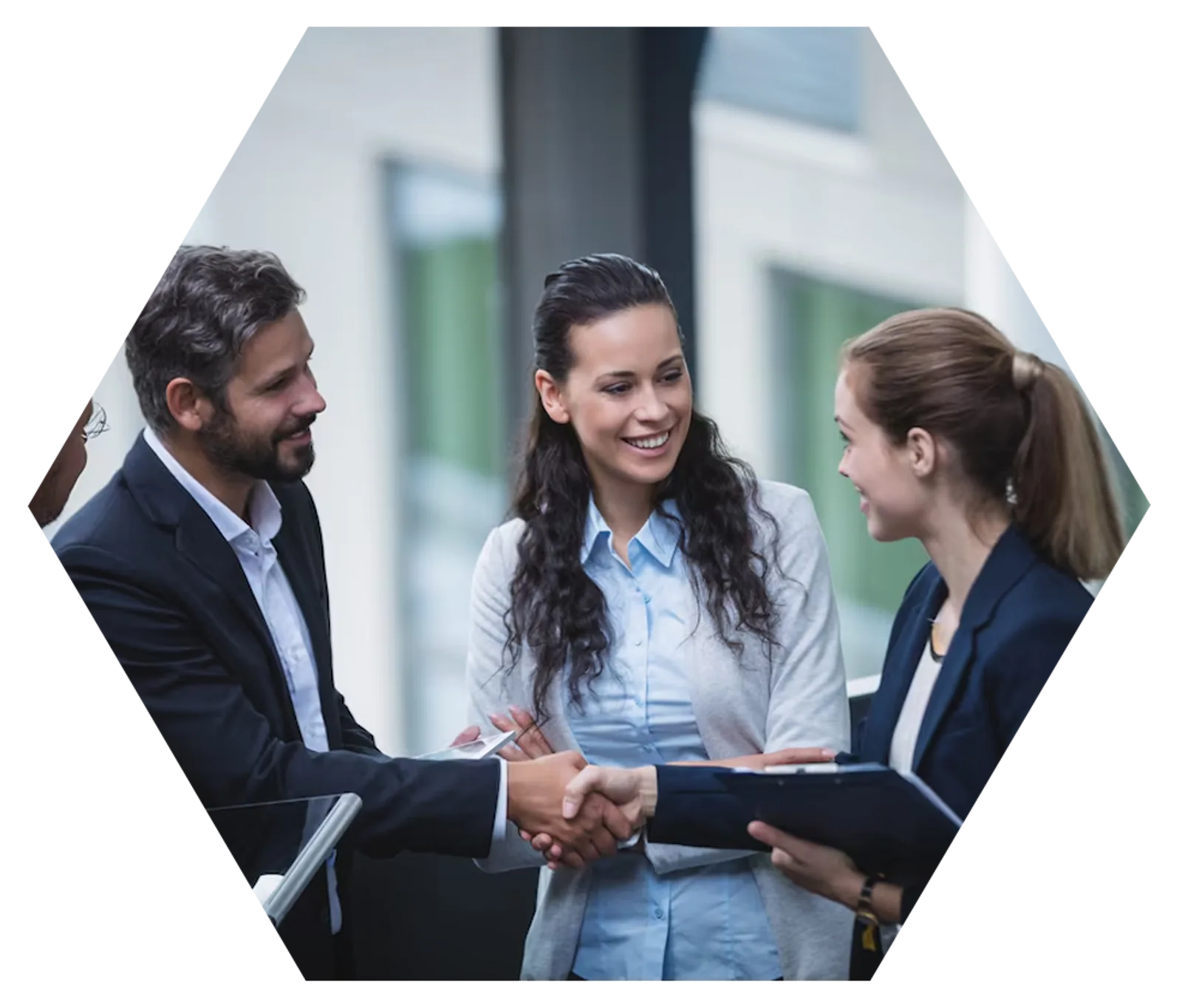 Three professionals shake hands during a meeting, demonstrating CAQA LLND's collaborative approach to resource development.