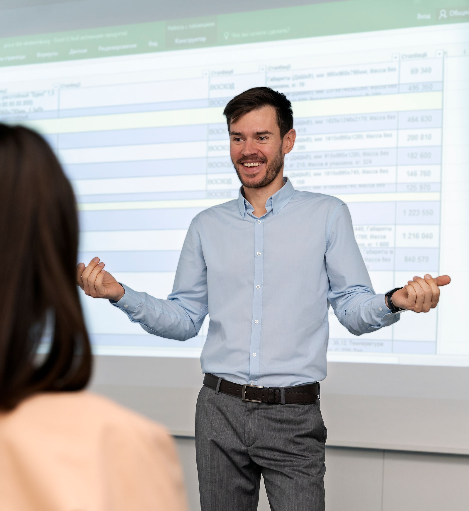 A man presents data from a spreadsheet during an office meeting illustrating llnd training delivery.