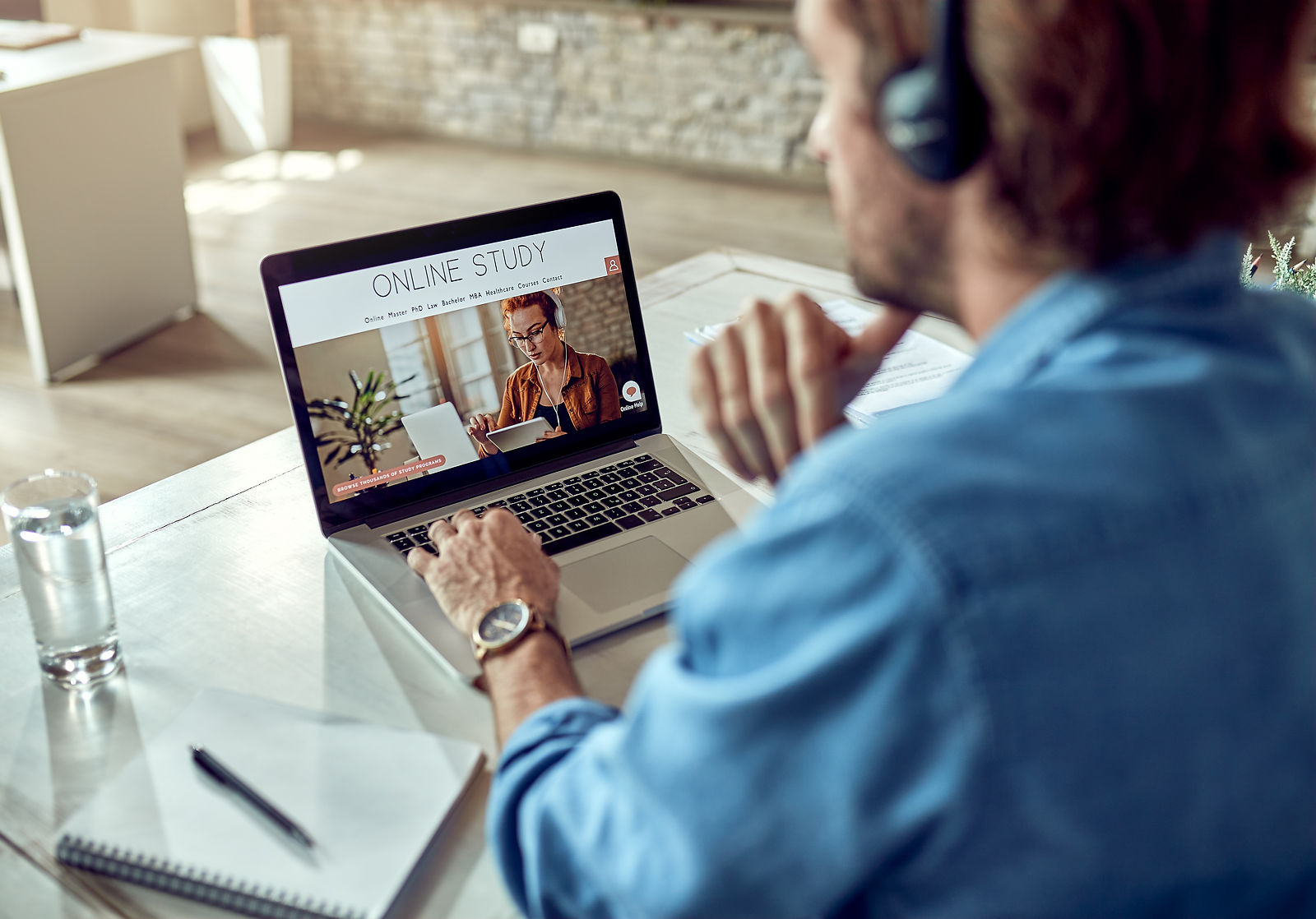 A person studies online using a laptop and headphones for foundation skills training.