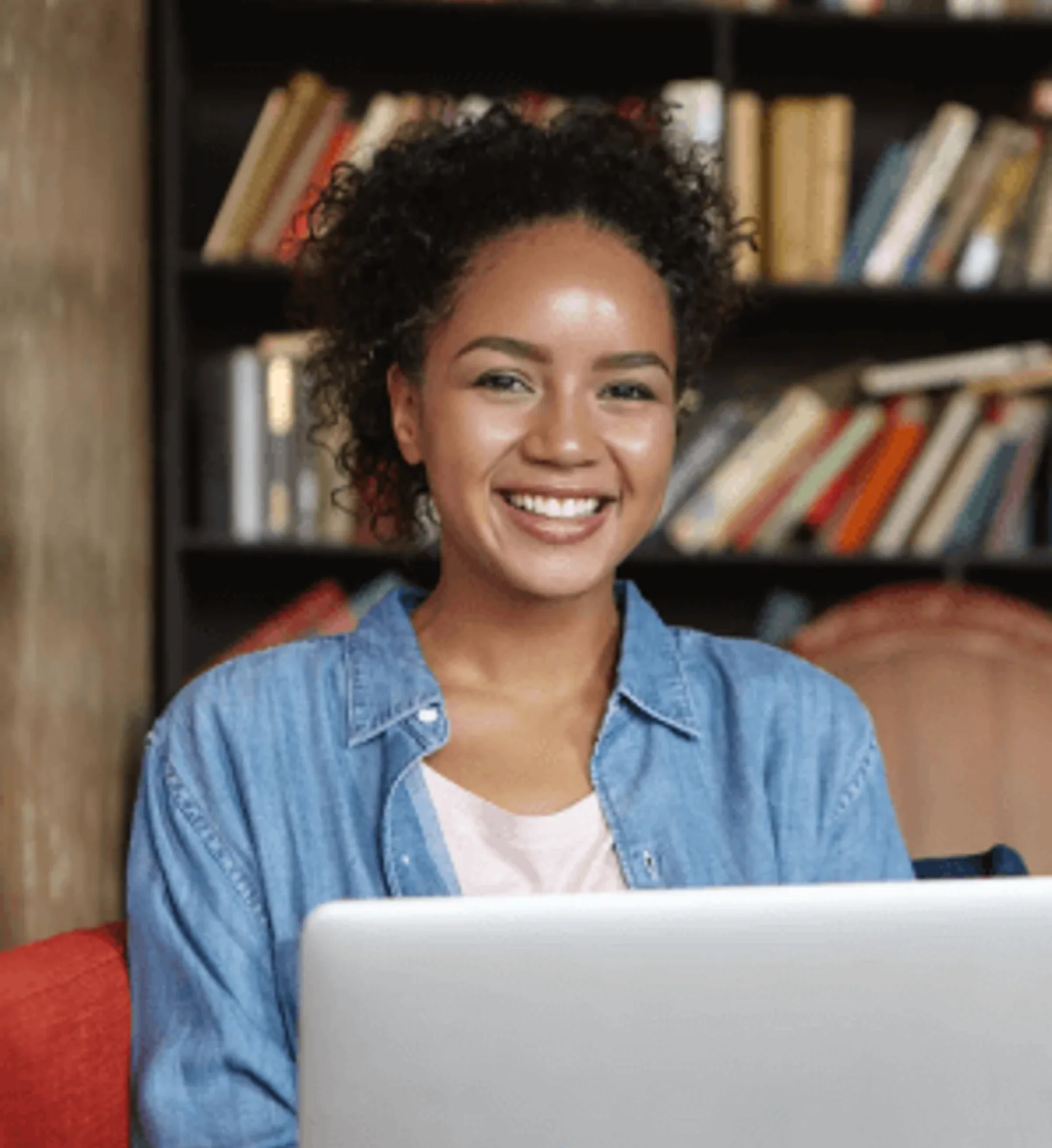 A woman celebrates successful LLND assessment results while working on a laptop.