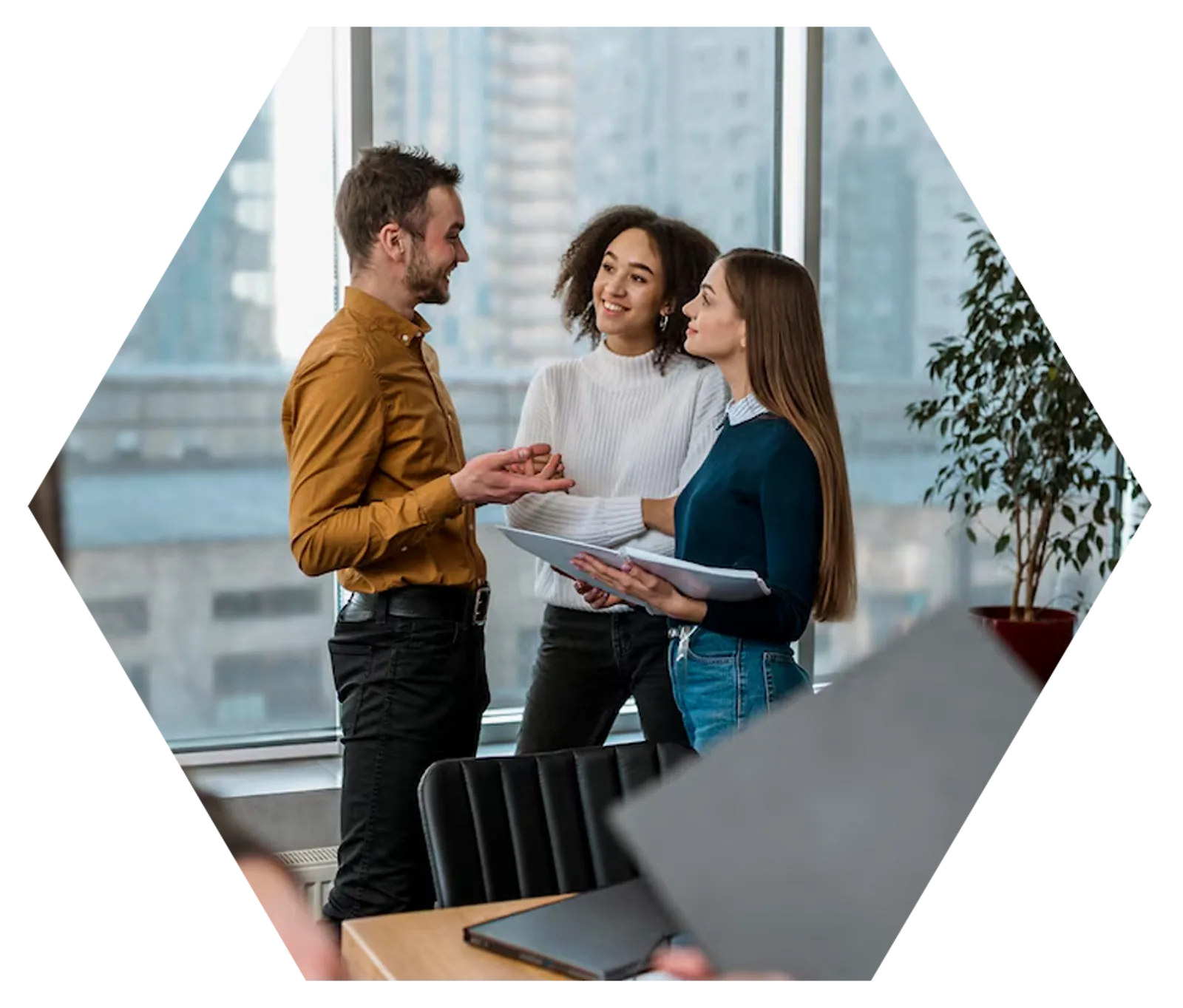 Three colleagues discuss documents in a modern office, demonstrating CAQA LLND's approach to resource development.