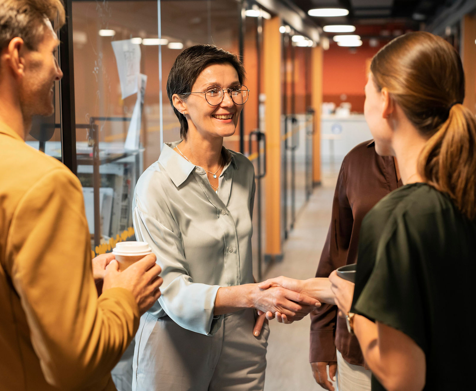 Two professionals shake hands during a business meeting, demonstrating CAQA LLND's commitment to partnership.