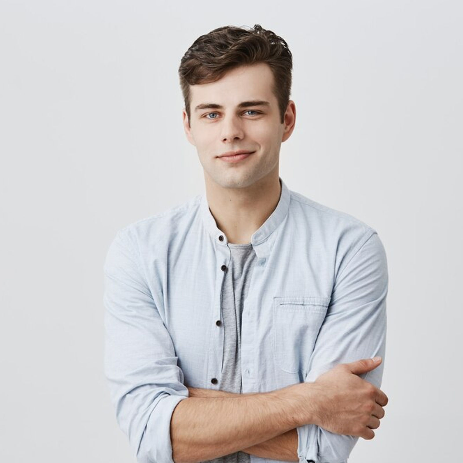 A young man with brown hair and blue eyes poses with crossed arms, representing employability skills training.