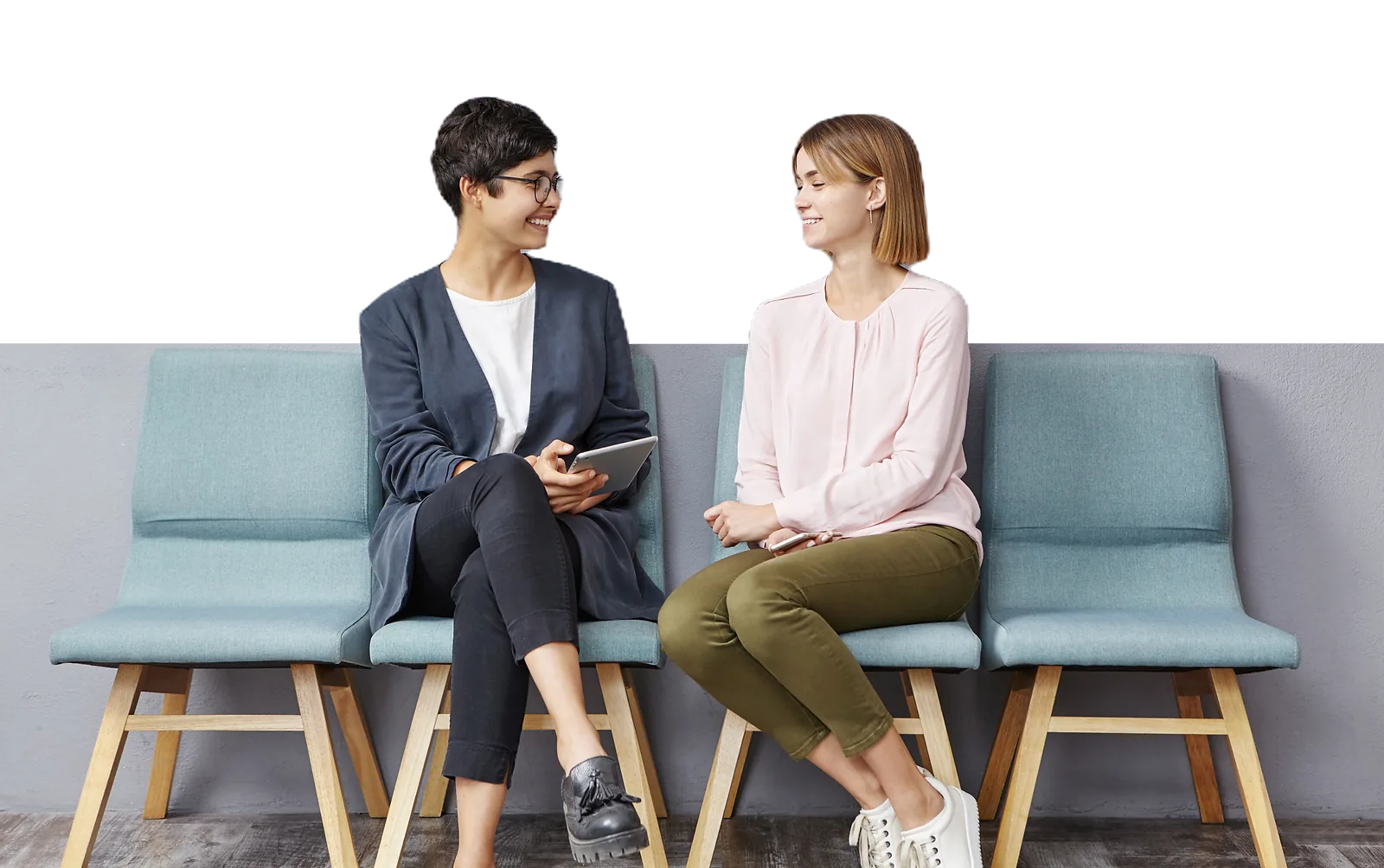 Two women are having a conversation in a waiting room, demonstrating employability skills.